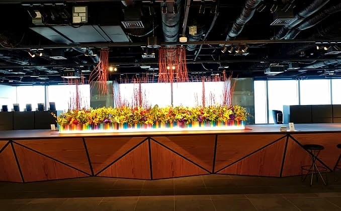 窓際の受付カウンターに横長に広がる迎春装花